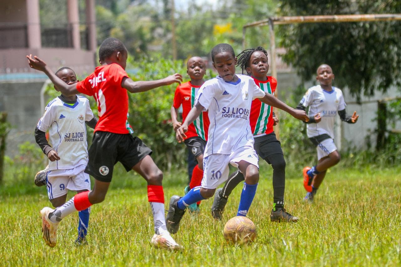 Young African footballers training at sunset with determination